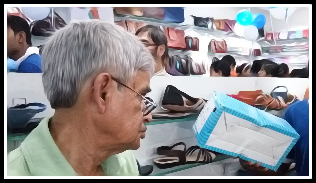 CLOSE-UP OF MAN WEARING EYEGLASSES ON TABLE