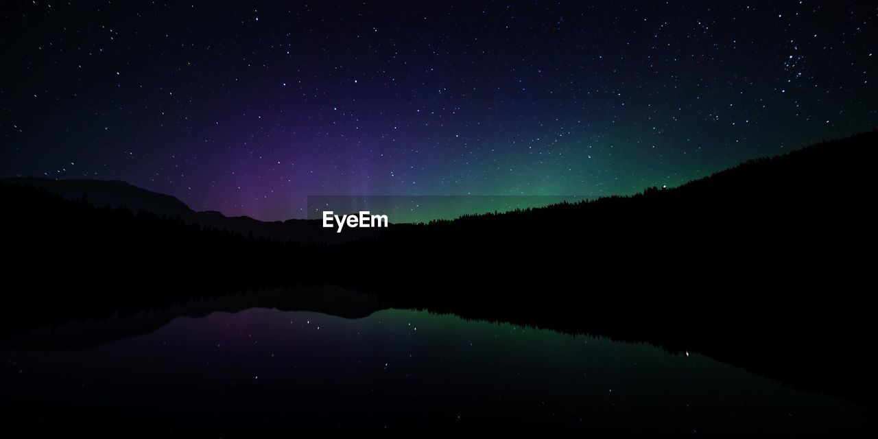 Scenic view of lake against sky at night