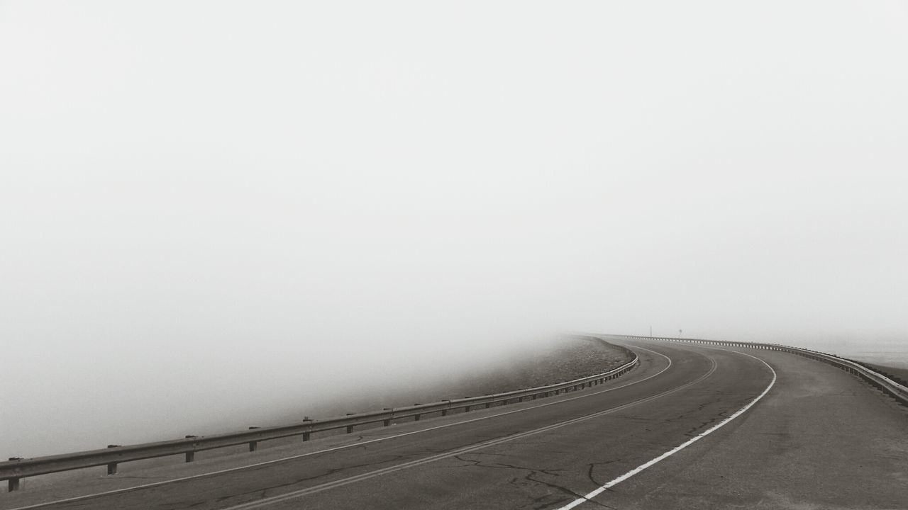 Empty road against sky during foggy weather
