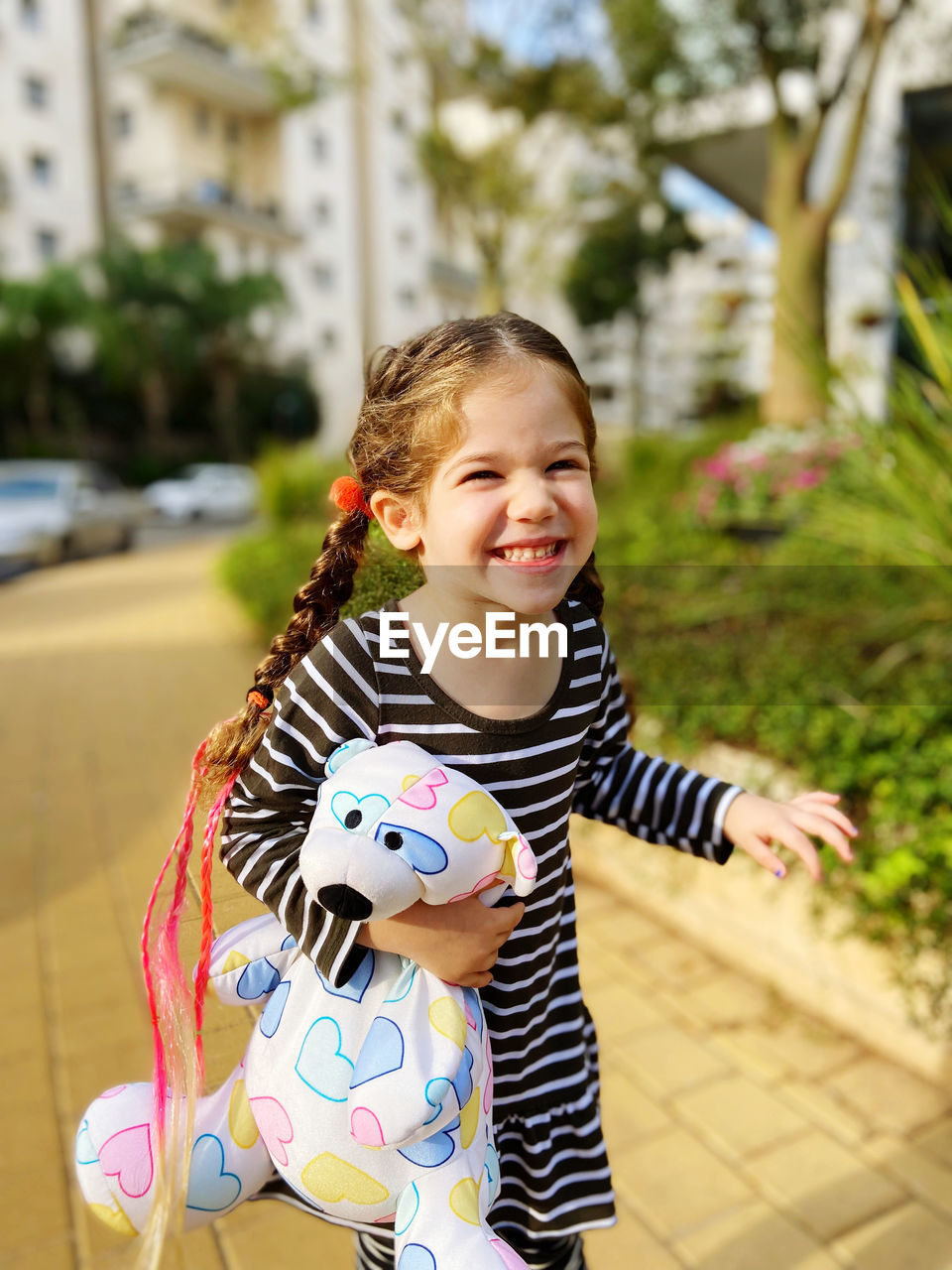 portrait of cute girl playing with toy on field