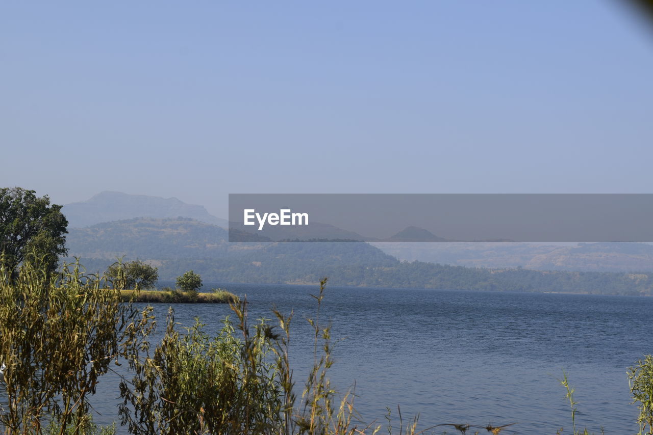 SCENIC VIEW OF LAKE AND MOUNTAINS AGAINST CLEAR SKY