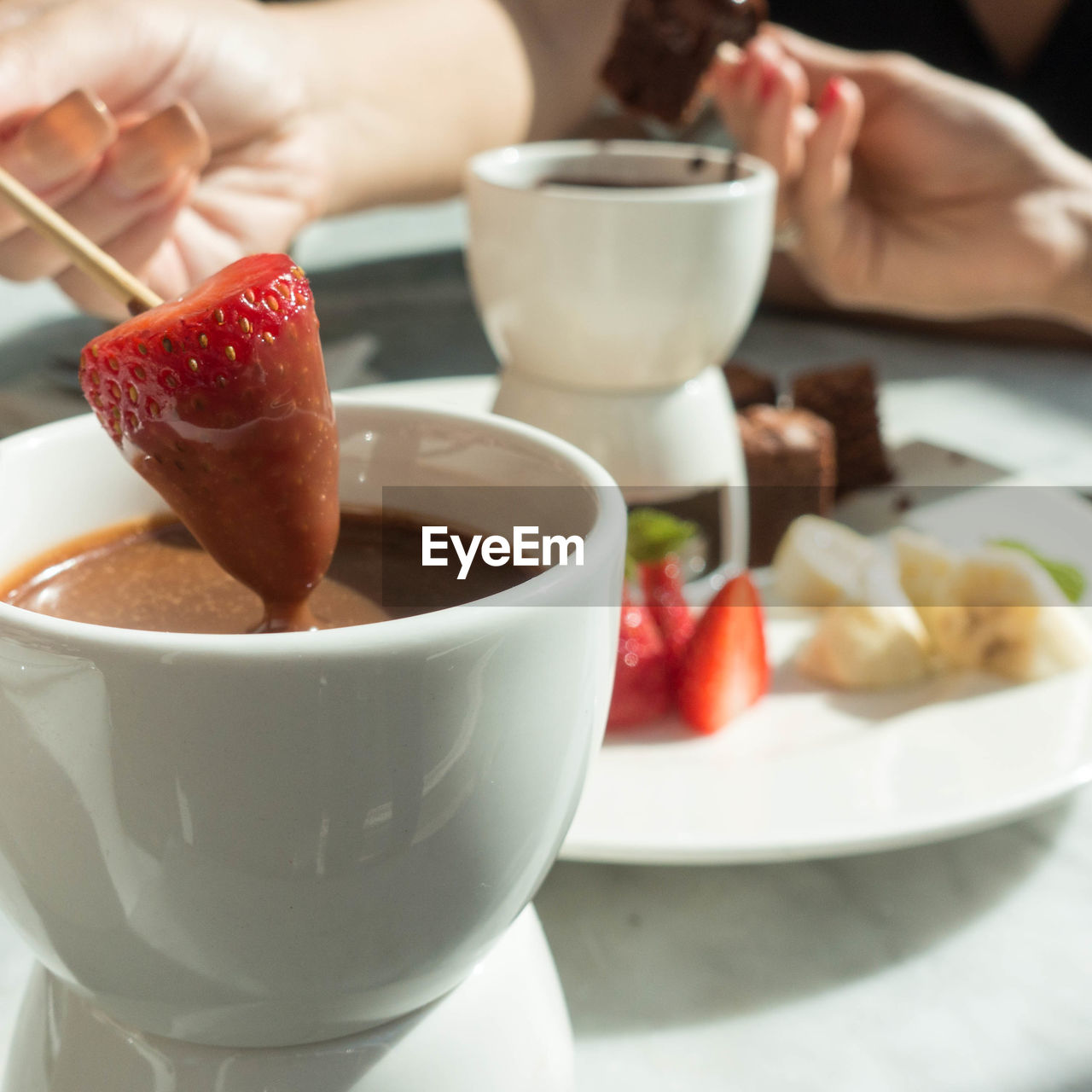 Cropped hands having food at table