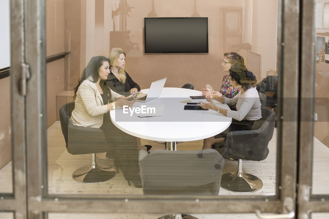 Businesswomen discussing in board room at creativity office
