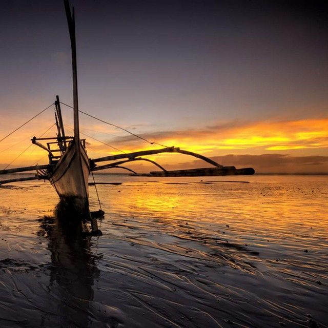 SAILBOATS IN SEA AT SUNSET