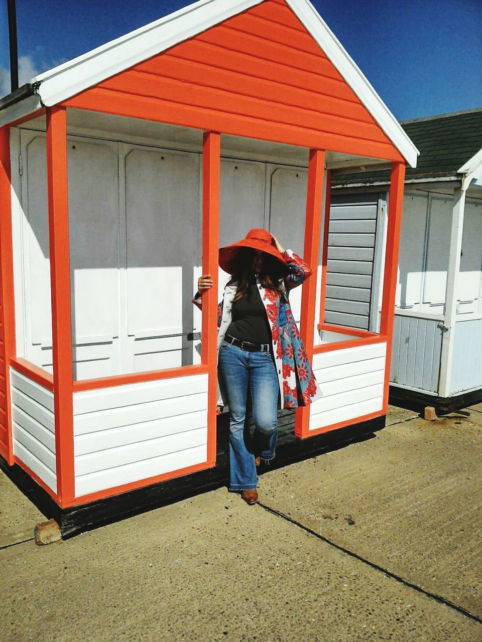 Woman standing by beach hut