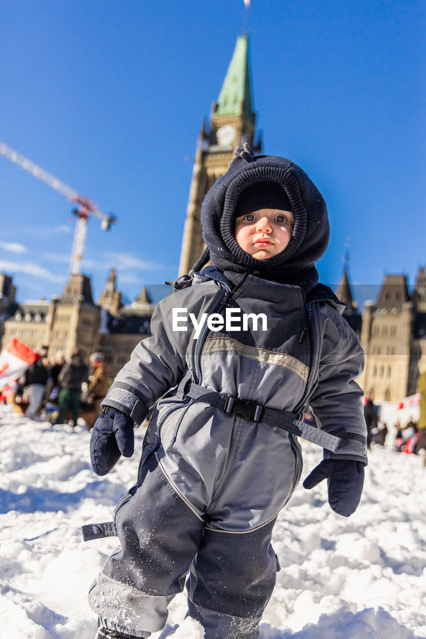 rear view of man standing on snow covered landscape