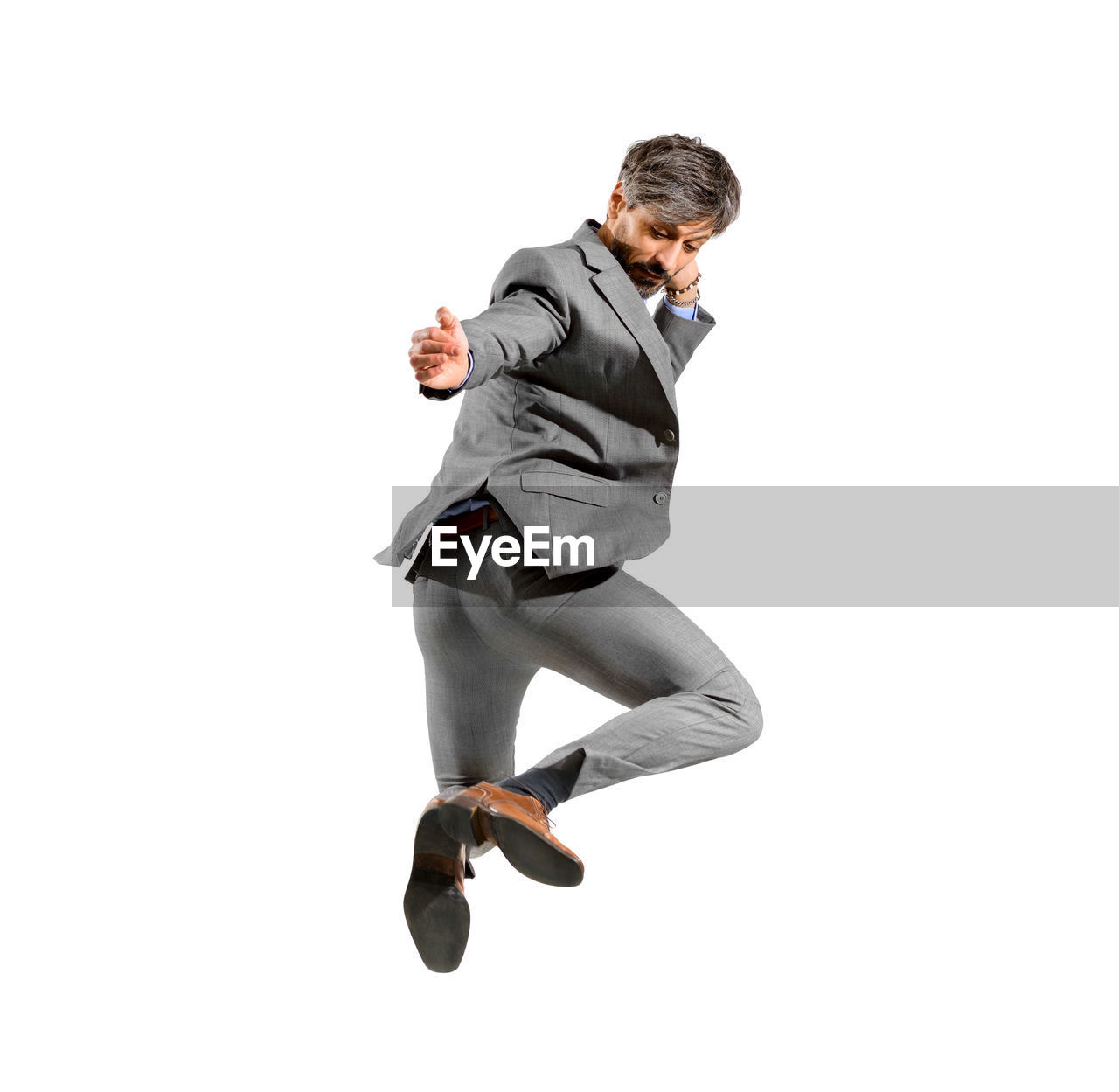 FULL LENGTH OF A MAN JUMPING AGAINST WHITE BACKGROUND