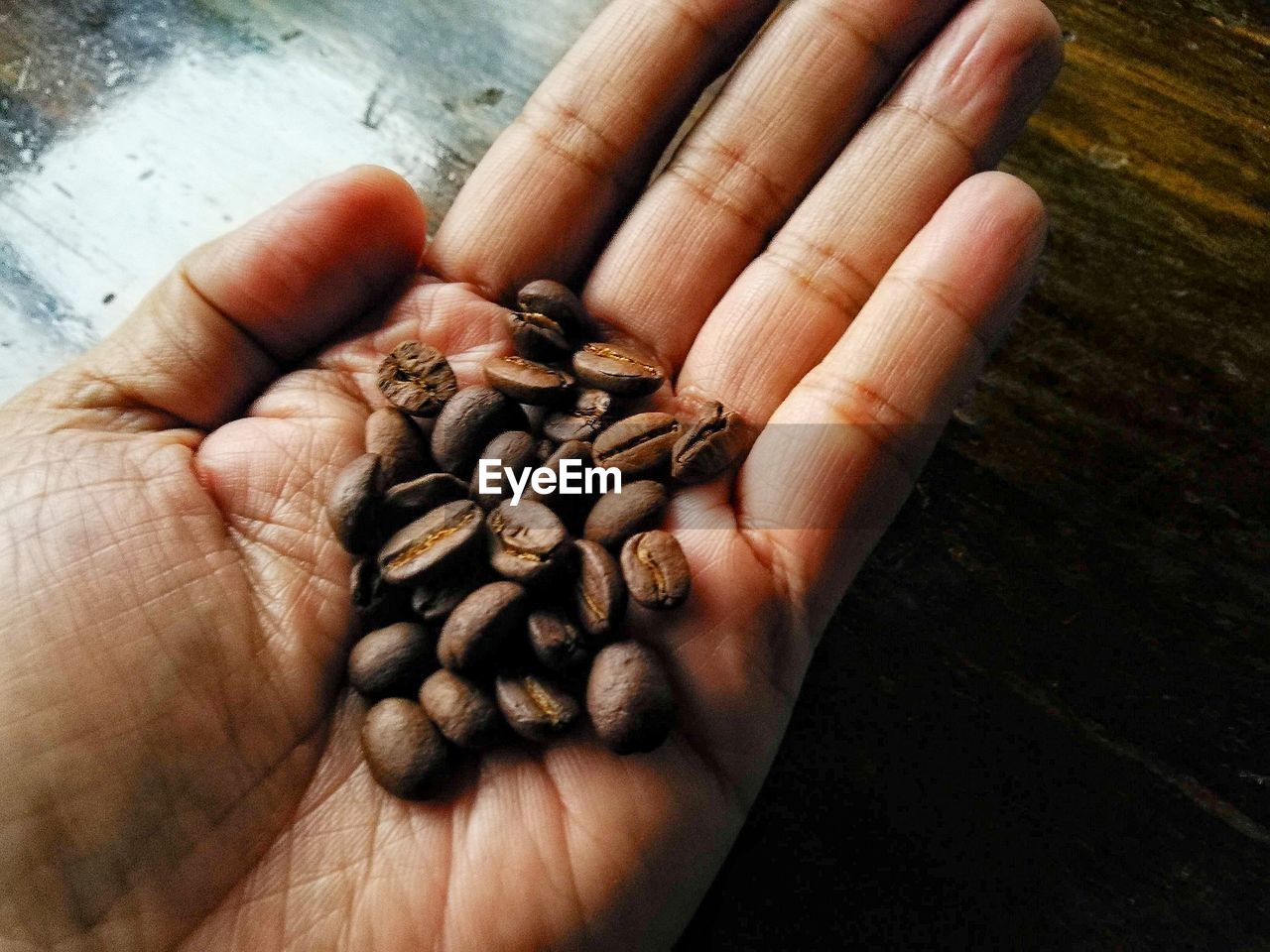 CROPPED IMAGE OF PERSON HOLDING COFFEE BEANS