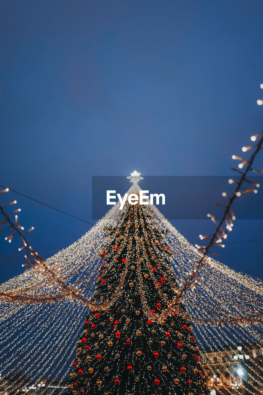 Festive sparkling golden garlands and  decorations with christmas tree as symbol of happy new year