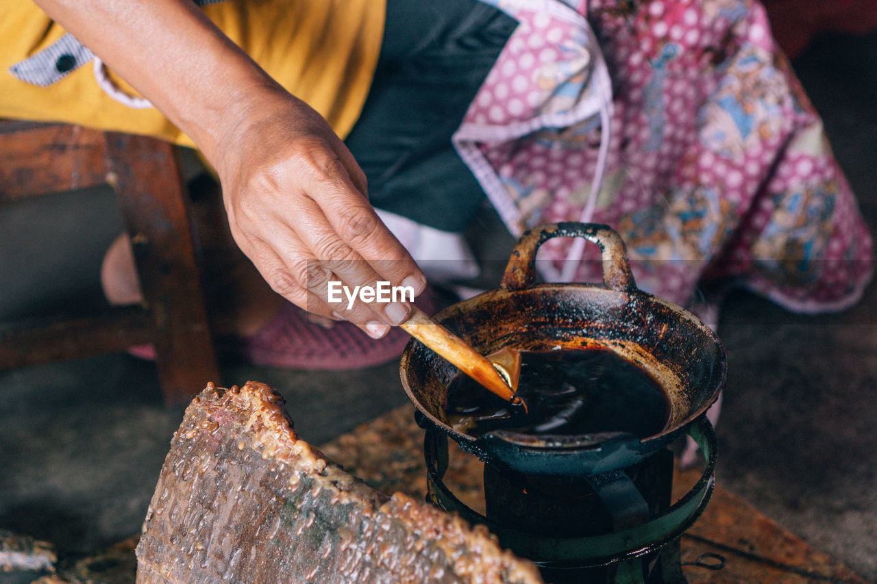 Midsection of person preparing food on stove