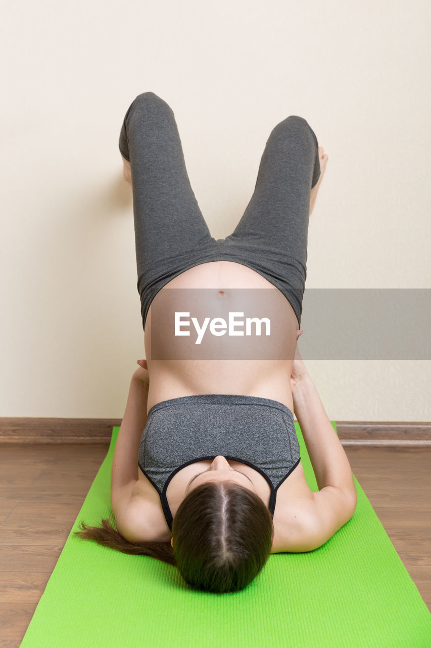 MIDSECTION OF WOMAN RELAXING AT HOME