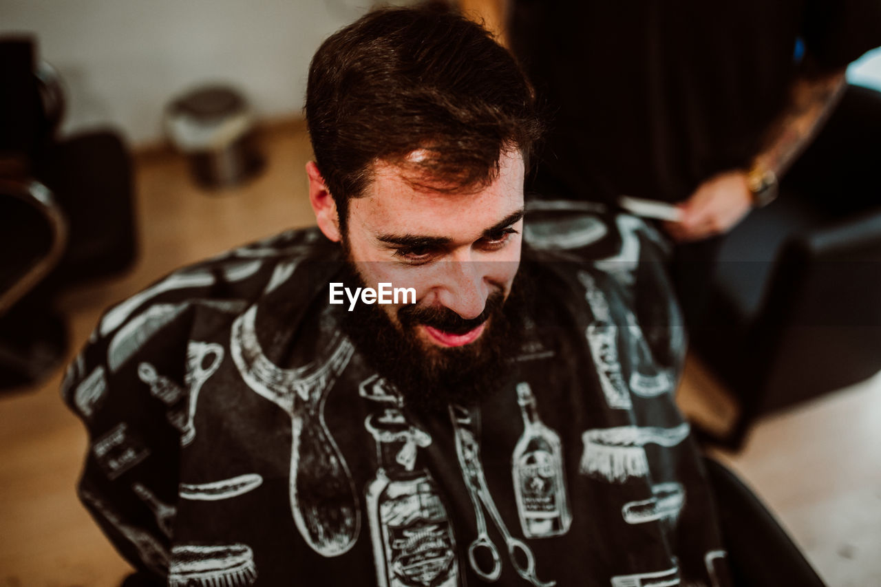 Cropped hands of barber grooming customer in salon