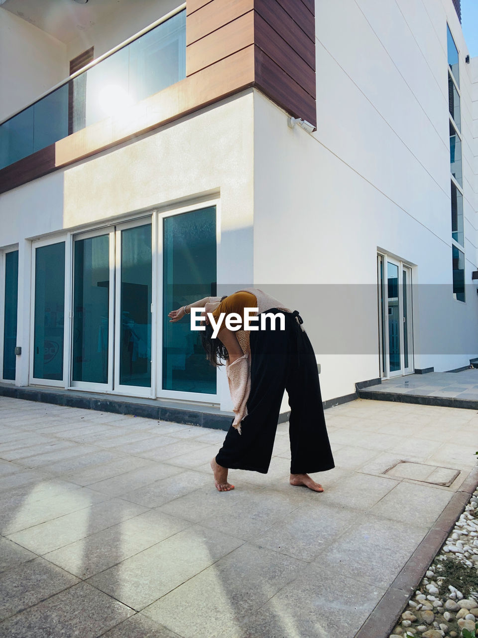 FULL LENGTH OF MAN STANDING AGAINST BUILDING