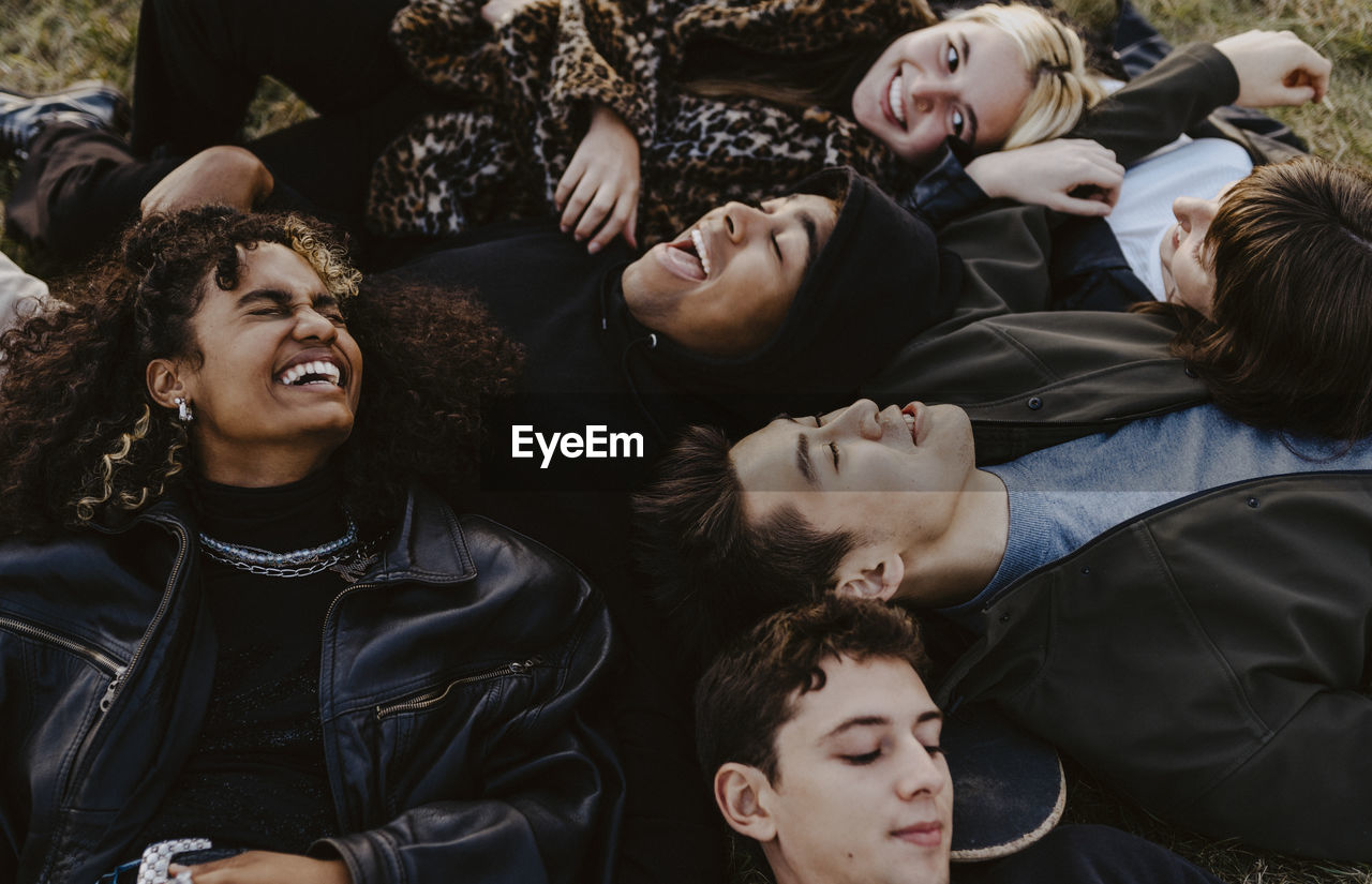 High angle view of male and female friends lying down during sunset