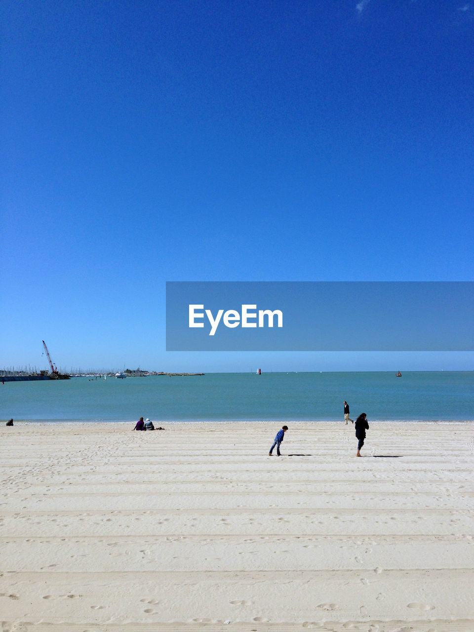 PEOPLE ON BEACH AGAINST CLEAR SKY