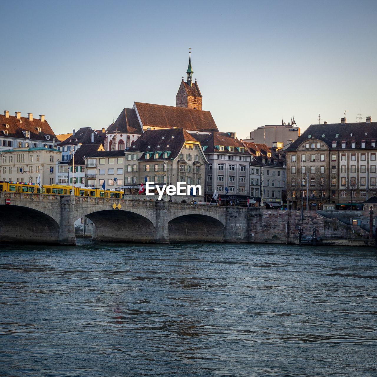 Arch bridge over river against buildings in city