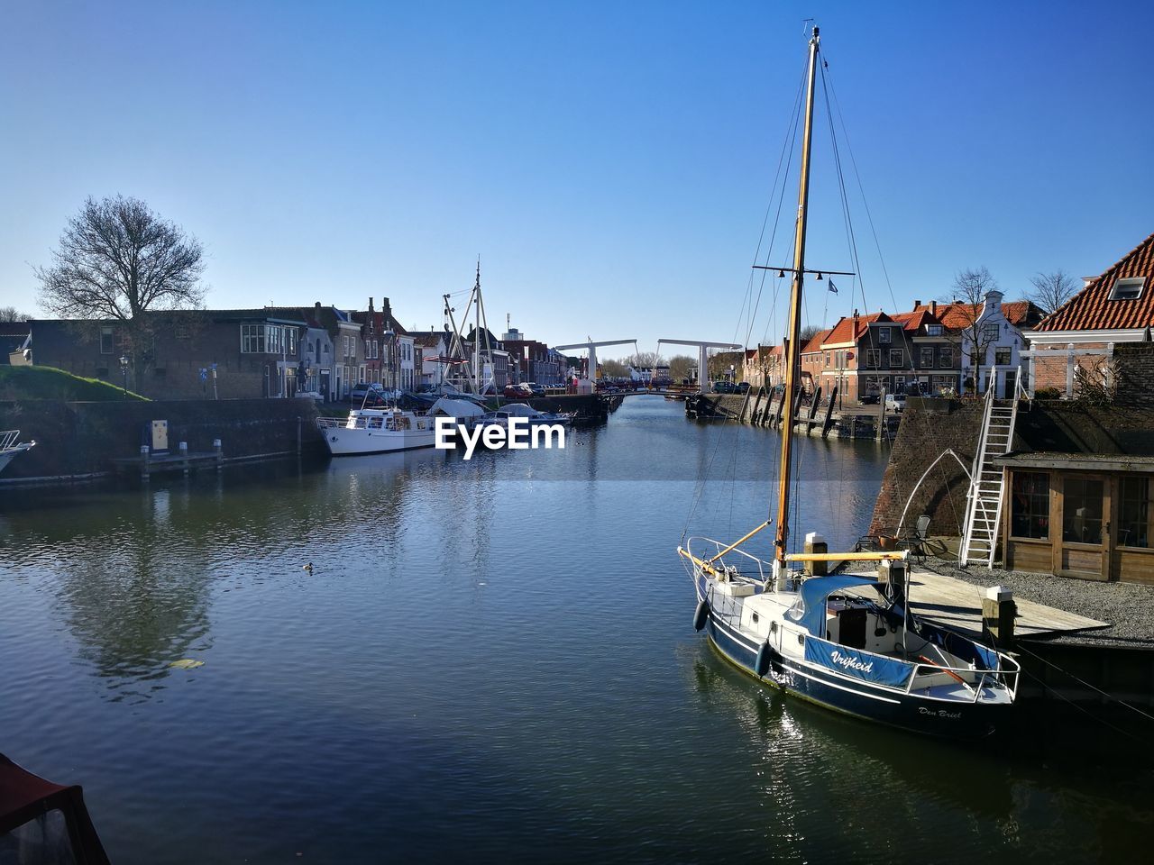 BOATS MOORED ON LAKE AGAINST CLEAR SKY