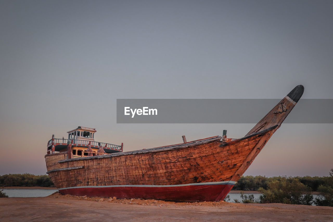 Boat on beach against clear sky