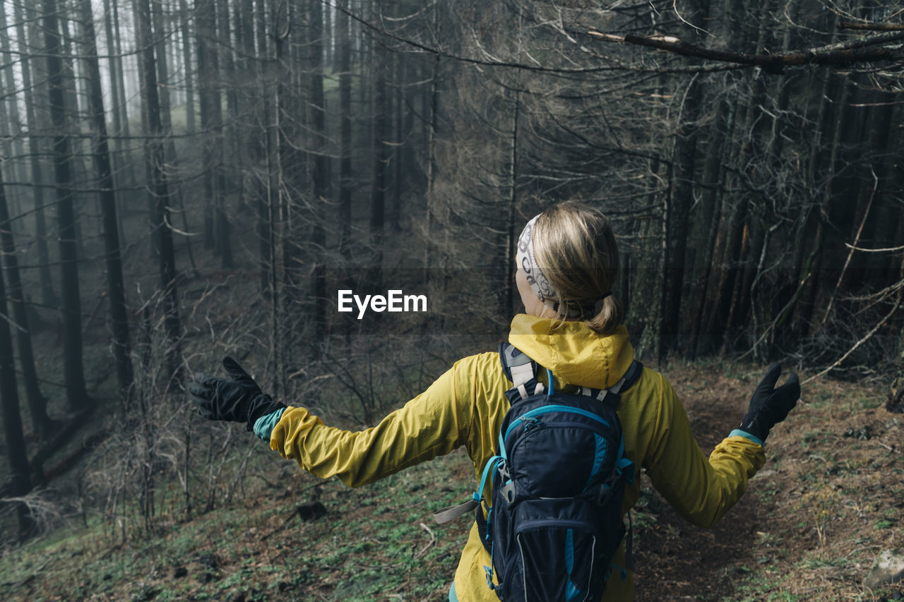 A young woman hikes along a trail in a forest in cascade locks, or.