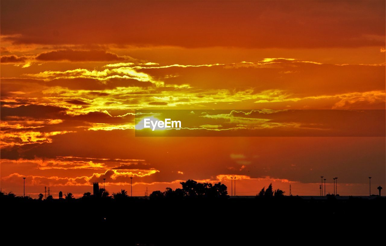 Scenic view of silhouette landscape against orange sky