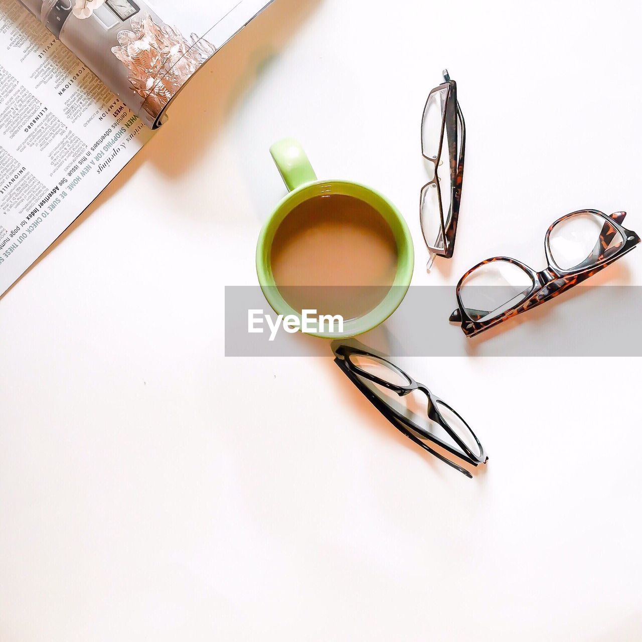 Directly above shot of coffee cup ad eyeglasses on table