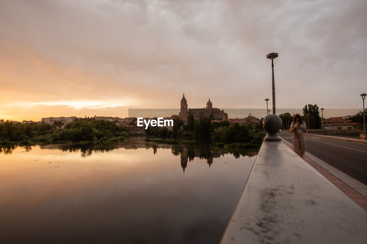 morning, reflection, sky, architecture, water, dusk, cloud, city, built structure, nature, travel destinations, building exterior, horizon, sunlight, street, travel, sunrise, religion, building, environment, landscape, history, twilight, transportation, sea, tourism, the past, outdoors, tree, beauty in nature, street light, sun, place of worship, plant, belief, no people, tranquility, tower, cityscape, scenics - nature, light