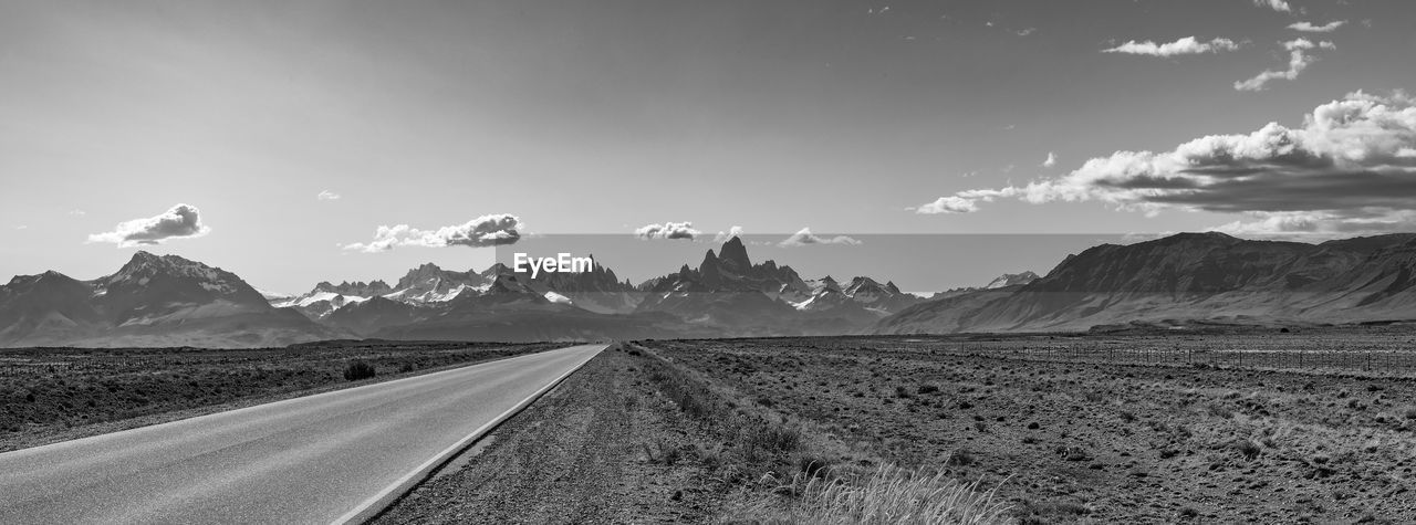 horizon, landscape, sky, environment, mountain, road, scenics - nature, black and white, nature, transportation, cloud, land, beauty in nature, mountain range, no people, monochrome photography, travel, monochrome, panoramic, the way forward, travel destinations, outdoors, tranquility, non-urban scene, tranquil scene, rural scene, desert, remote