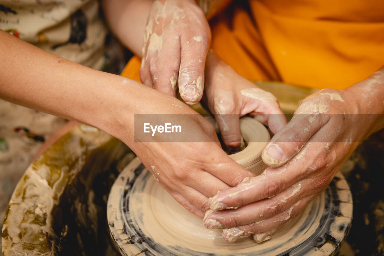 Cropped hands of potter making pot