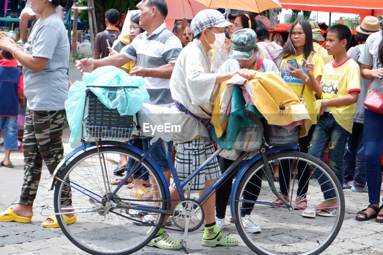 PEOPLE STANDING BY BICYCLES ON STREET