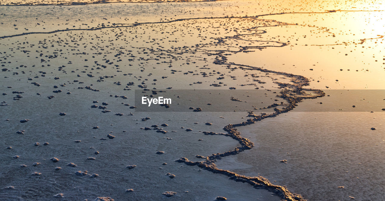 HIGH ANGLE VIEW OF WET SAND