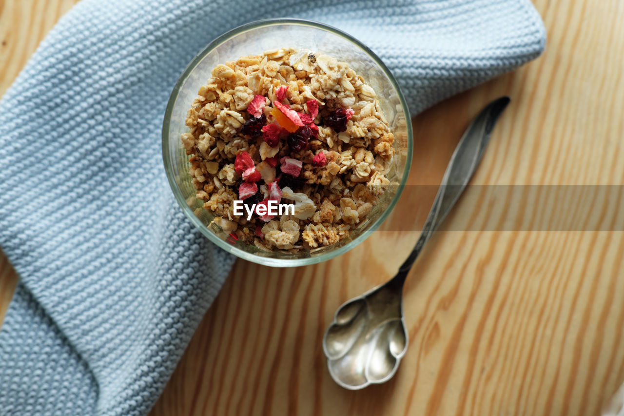 Granola in a glass on wooden table