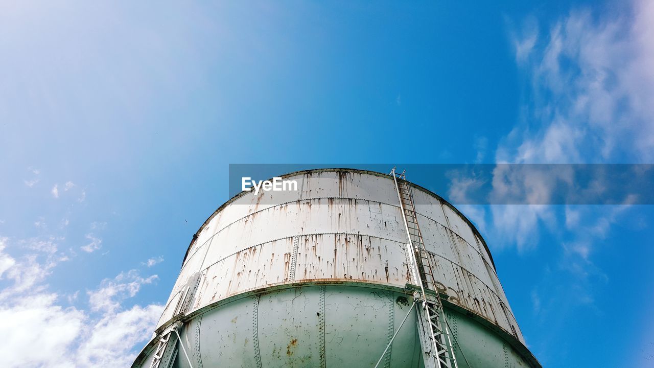 Low angle view of water tower against blue sky