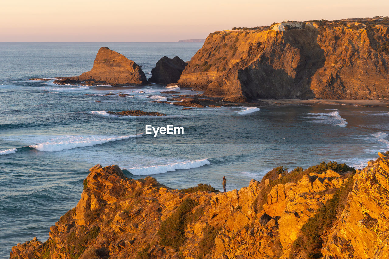 Scenic view of rocks on beach against sky