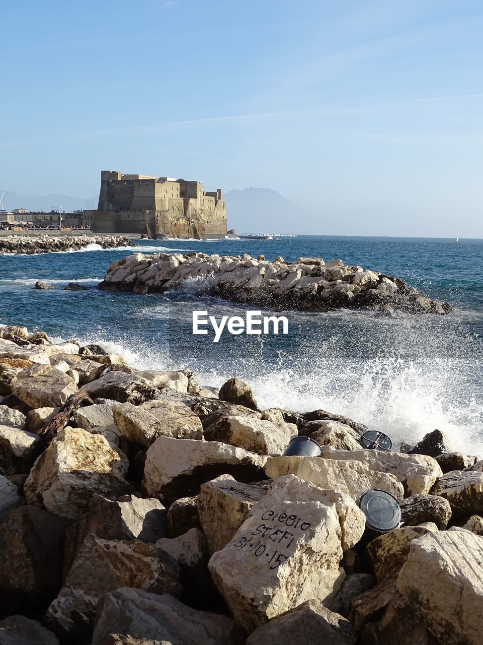 ROCKS BY SEA AGAINST CLEAR SKY