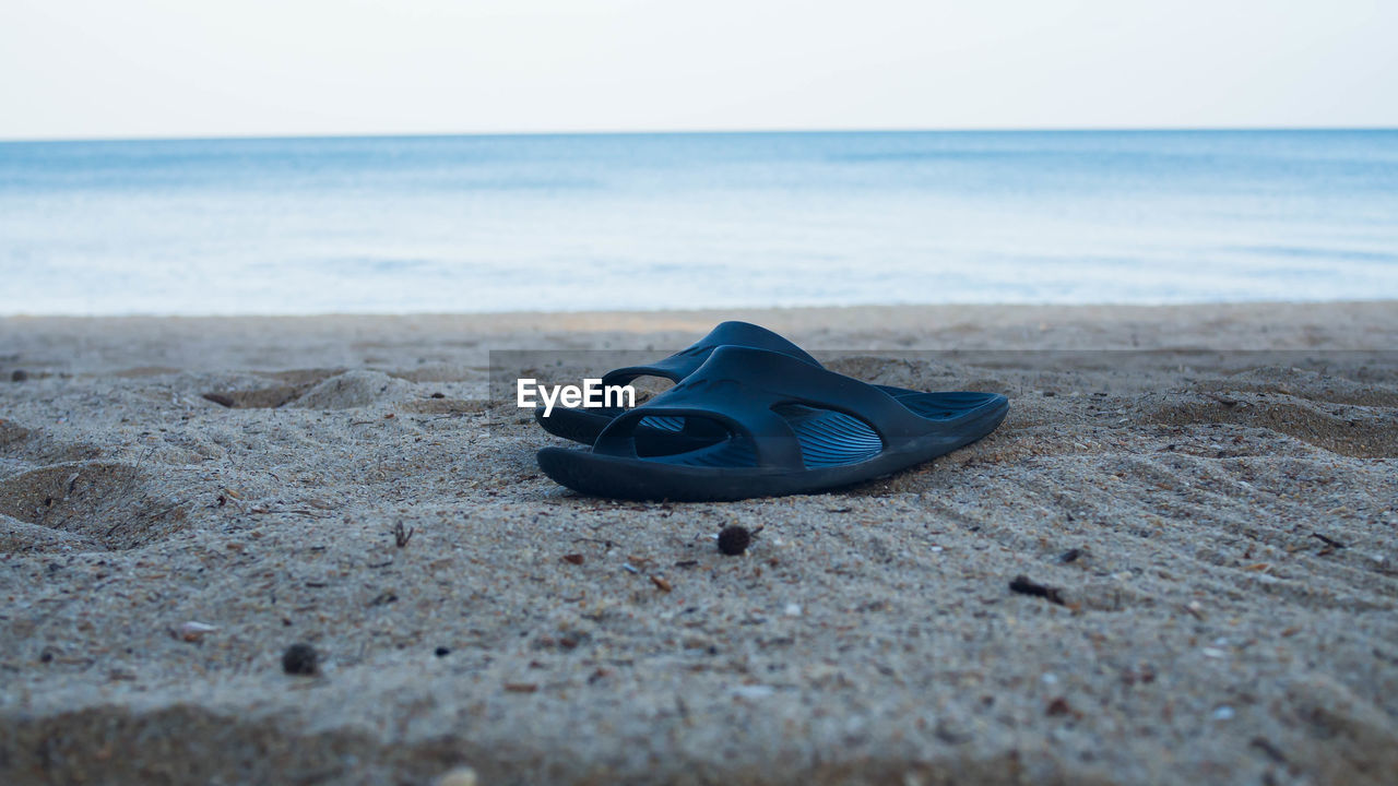 CLOSE-UP OF SHOES ON BEACH