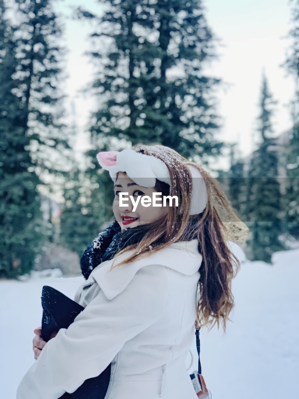 Portrait of beautiful woman standing on snow