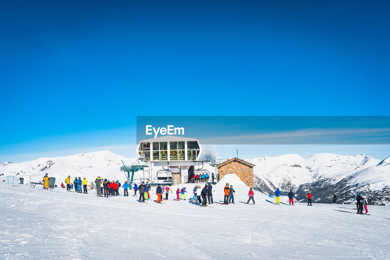 Skiers and snowboarders taking off from ski lift and having fun in winter, andorra