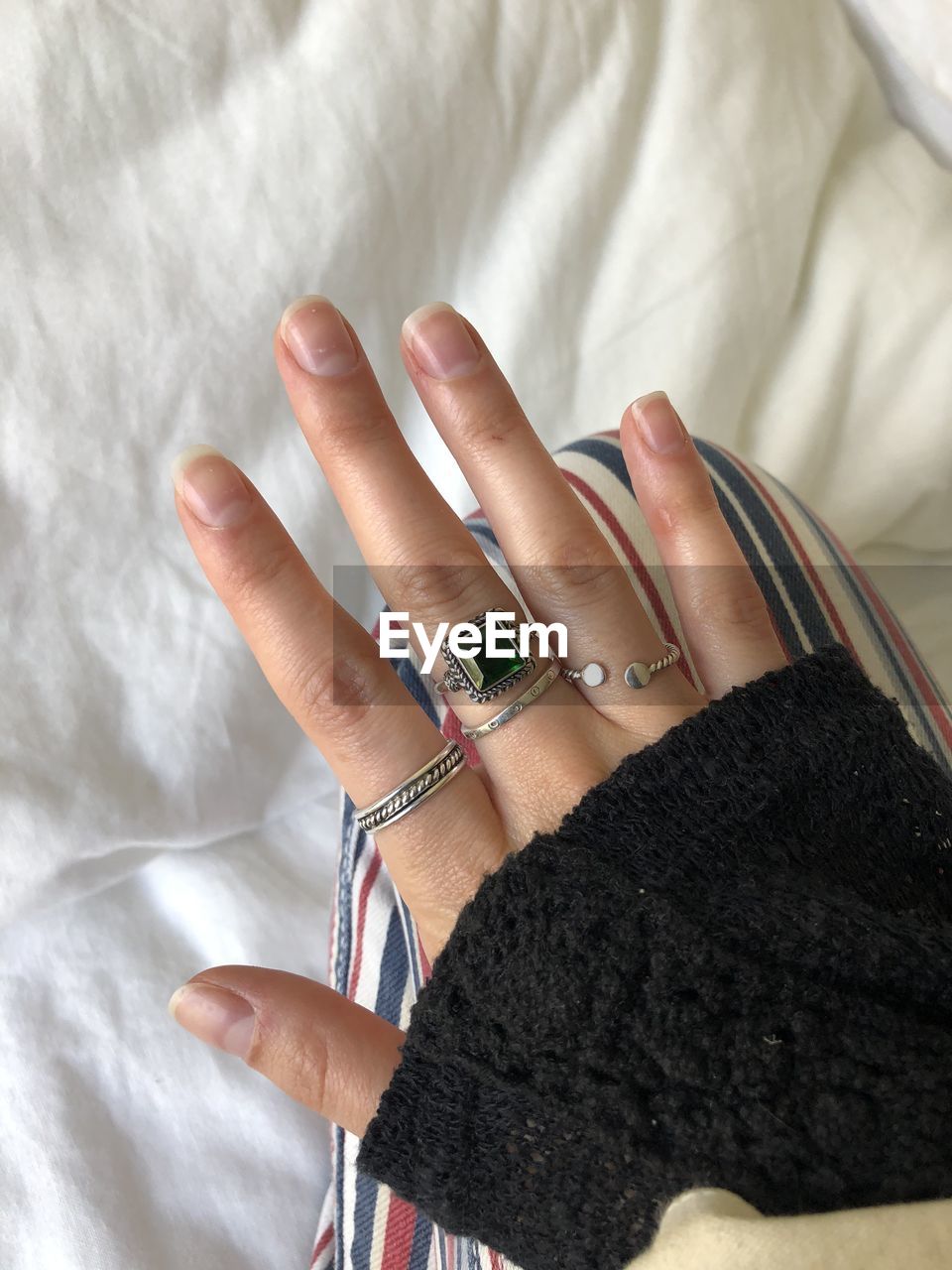 Close-up of woman hand on bed