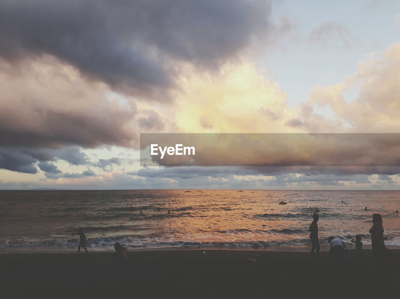 Scenic view of sea against cloudy sky during sunset