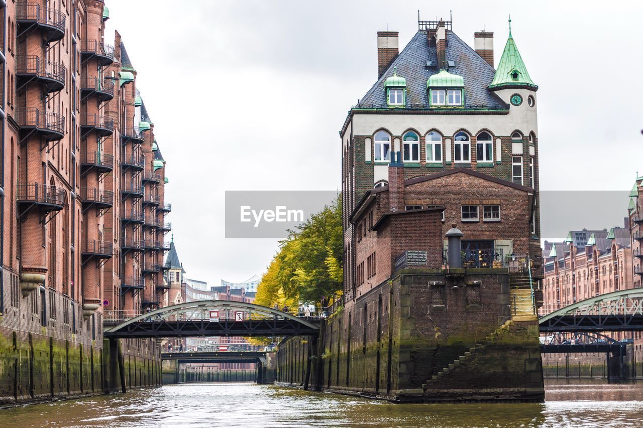 BRIDGE OVER RIVER AGAINST SKY IN CITY