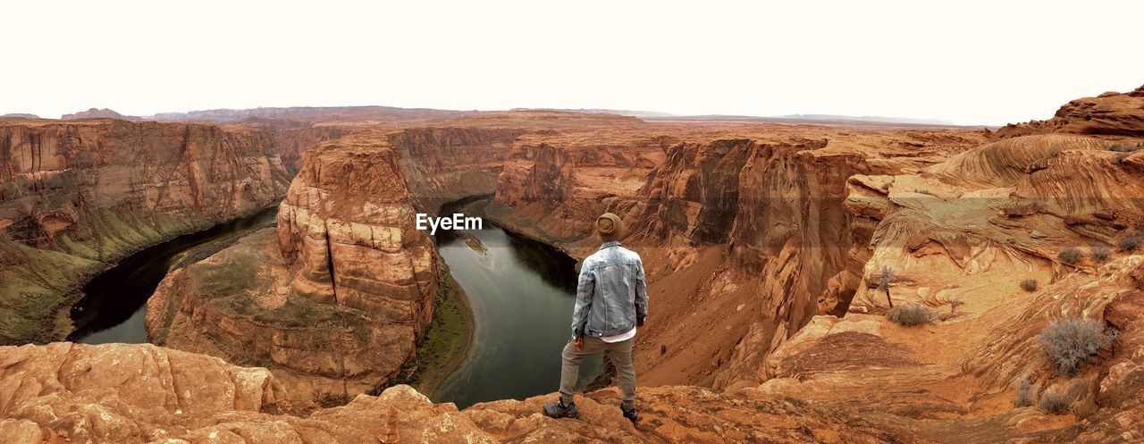 Full length of man looking at view while standing on rock