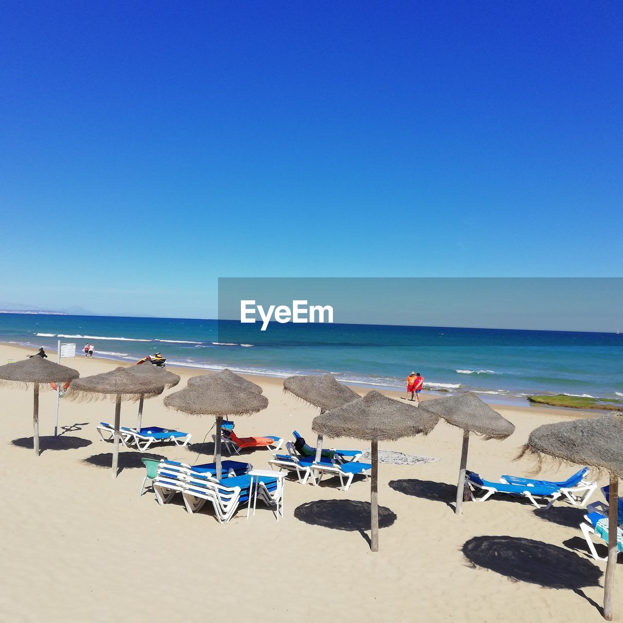 Scenic view of beach against clear blue sky