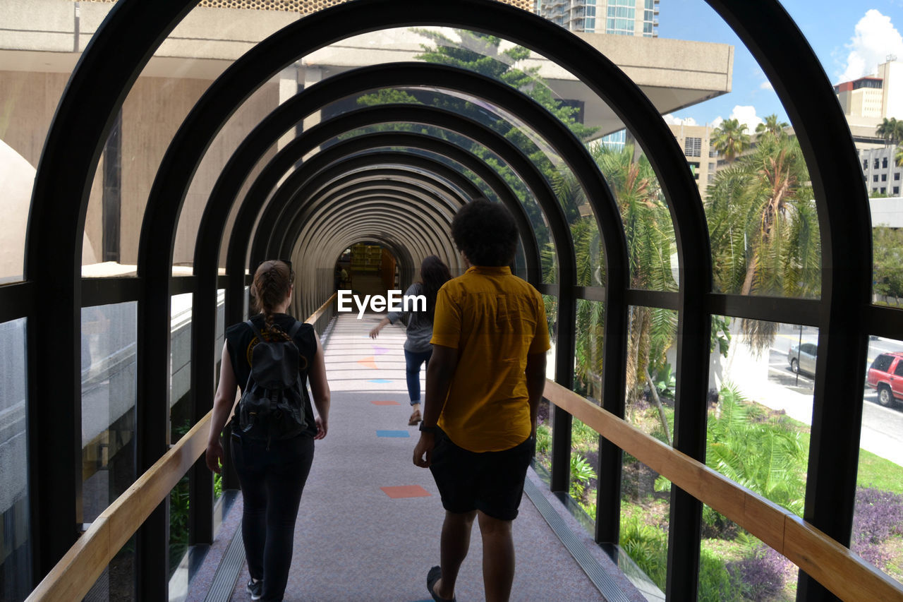 REAR VIEW OF WOMAN STANDING IN TUNNEL