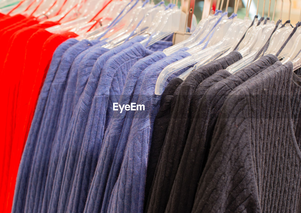 CLOSE-UP OF CLOTHES HANGING ON RACK