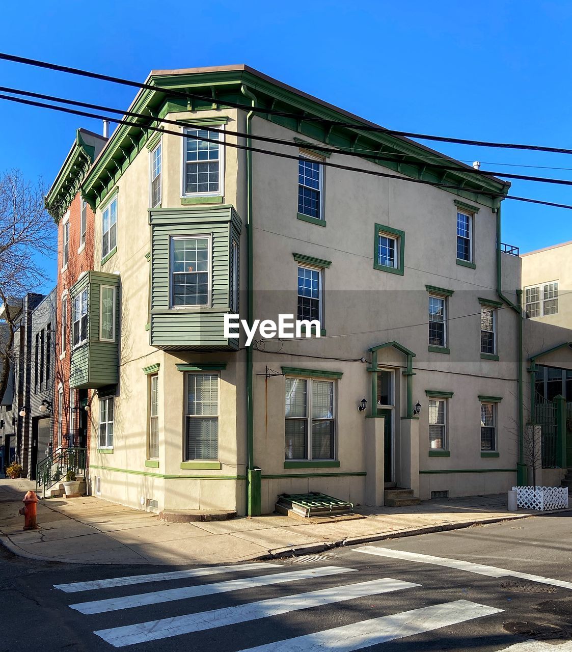 Street by buildings against blue sky