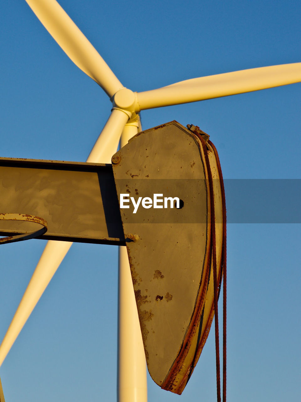 Low angle view of windmill against clear blue sky