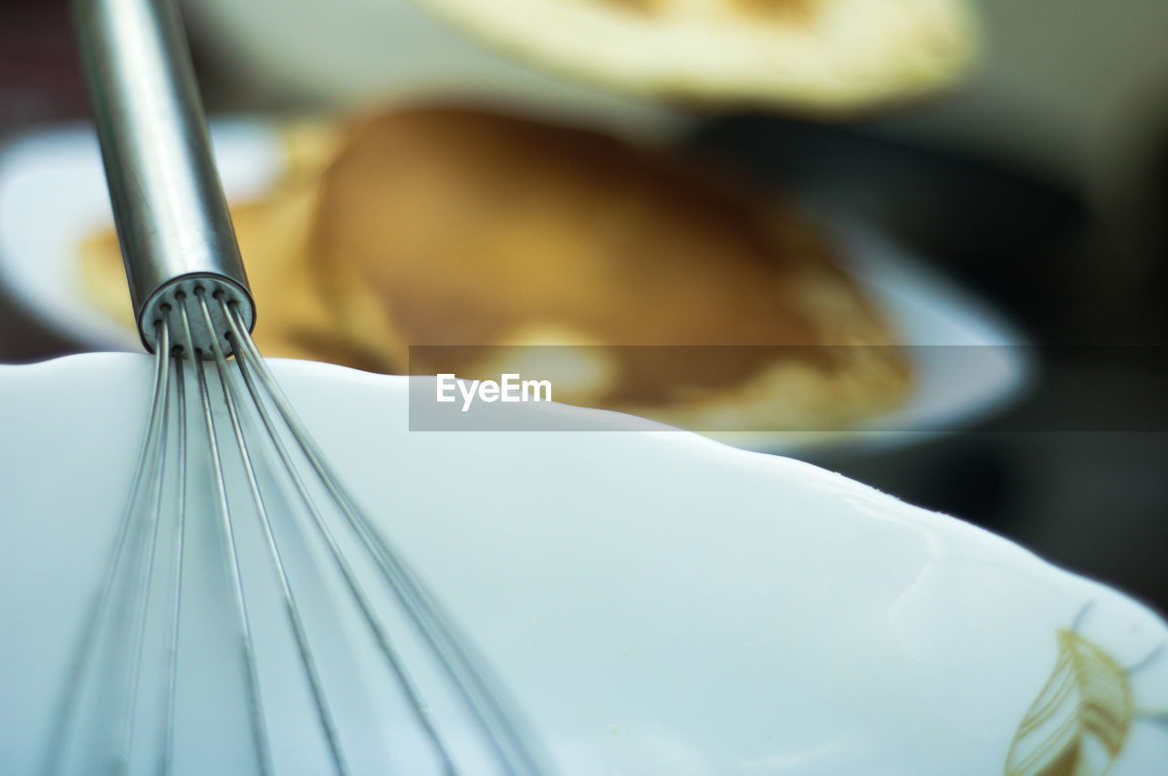 Close-up of wire whisk on plate