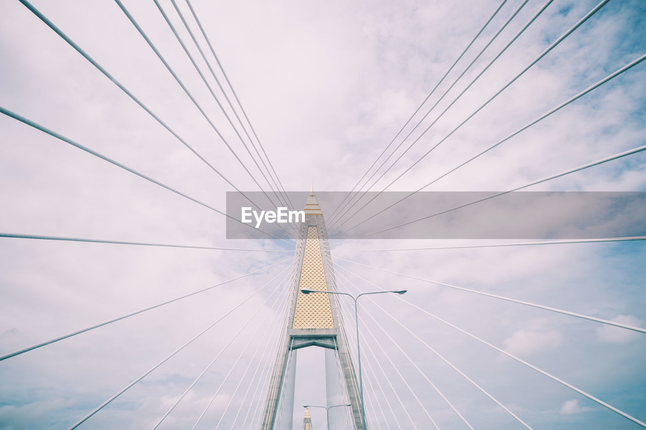 Low angle view of bridge against cloudy sky
