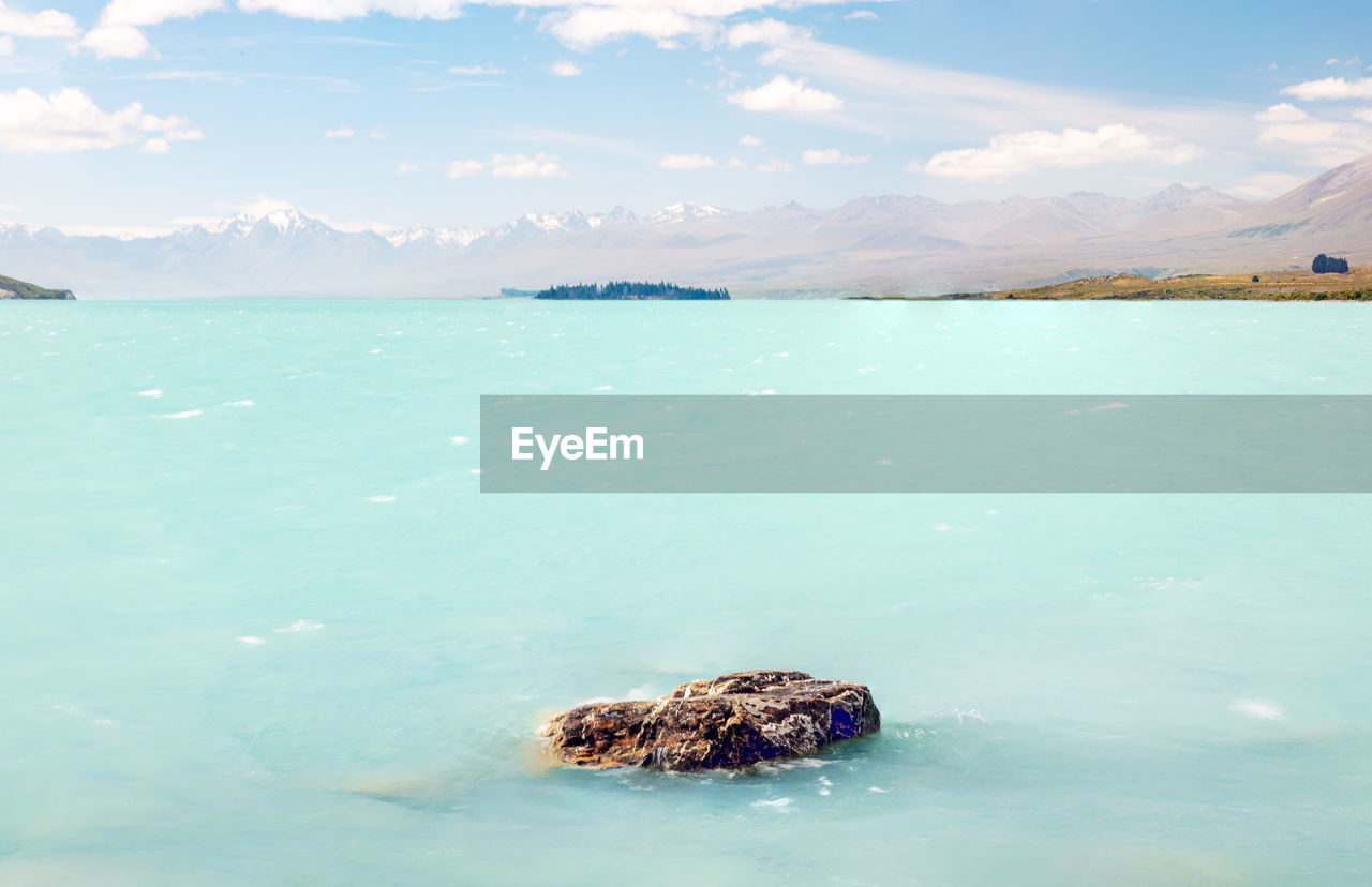Scenic view of  turquoise water in lake tekapo against sky