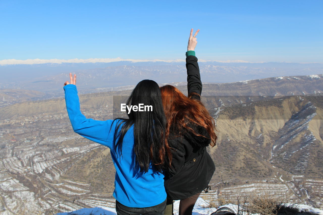 REAR VIEW OF WOMAN AGAINST SKY